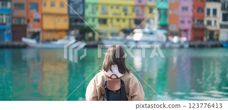 woman traveler visiting in Taiwan, female Tourist with backpack sightseeing at Keelung, Colorful Zhengbin Fishing Port. Popular landmarks and attractions near Taipei City.  Asia Travel concept 123776413