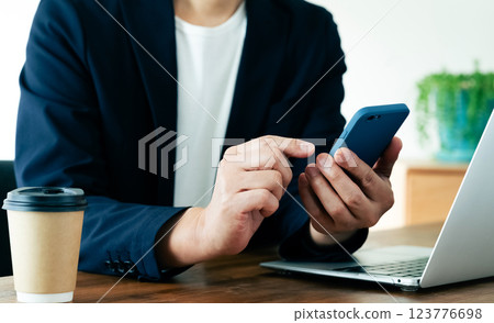 一個操作電腦和智能手機的人 123776698