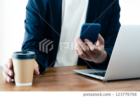 一個操作電腦和智能手機的人 123776708