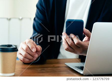 一個操作電腦和智能手機的人 一個操作電腦和智能手機的人 123776709