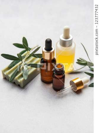 Natural olive oil cosmetic products with olive tree branch on grey table 123777432