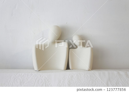 A ceramic object with the upper body motif of what appears to be a man and woman, photographed against a white background A ceramic object with the upper body motif of what appears to be a man and woman, photographed against a white background 123777856