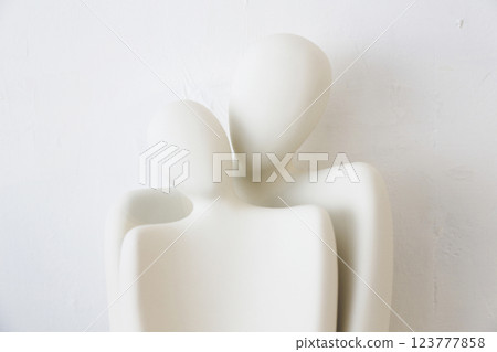 A ceramic object with the upper body motif of what appears to be a man and woman, photographed against a white background A ceramic object with the upper body motif of what appears to be a man and woman, photographed against a white background 123777858
