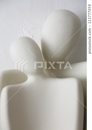 A ceramic object with the upper body motif of what appears to be a man and woman, photographed against a white background A ceramic object with the upper body motif of what appears to be a man and woman, photographed against a white background 123777859