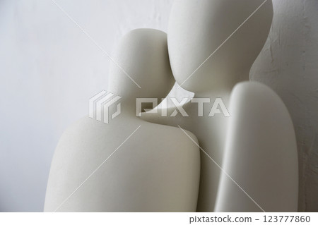 A ceramic object with the upper body motif of what appears to be a man and woman, photographed against a white background A ceramic object with the upper body motif of what appears to be a man and woman, photographed against a white background 123777860