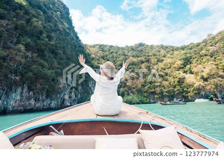 Happy Woman tourist in private longtail boat trip to koh Hong lagoon island at Krabi, Thailand. landmark, tropical destination, southeast Asia Travel, summer vacation, wanderlust and holiday concept Happy Woman tourist in private longtail boat trip to koh Hong lagoon island at Krabi, Thailand. landmark, tropical destination, southeast Asia Travel, summer vacation, wanderlust and holiday concept 123777974