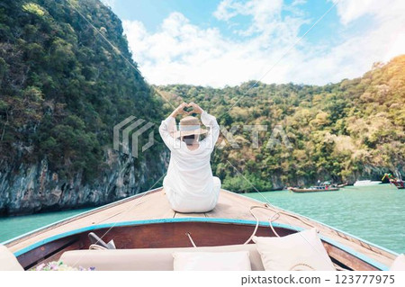 Happy Woman tourist in private longtail boat trip to koh Hong lagoon island at Krabi, Thailand. landmark, tropical destination, southeast Asia Travel, summer vacation, wanderlust and holiday concept Happy Woman tourist in private longtail boat trip to koh Hong lagoon island at Krabi, Thailand. landmark, tropical destination, southeast Asia Travel, summer vacation, wanderlust and holiday concept 123777975