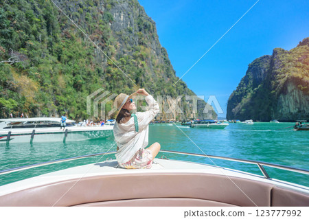 Woman tourist on boat trip, happy traveller relaxing at Pileh lagoon on Phi Phi island, Krabi, Thailand. Exotic landmark, destination Southeast Asia Travel, summer vacation and holiday concept Woman tourist on boat trip, happy traveller relaxing at Pileh lagoon on Phi Phi island, Krabi, Thailand. Exotic landmark, destination Southeast Asia Travel, summer vacation and holiday concept 123777992