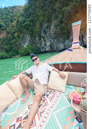Happy man tourist in private longtail boat trip to koh Hong lagoon island at Krabi, Thailand. landmark, tropical destination, southeast Asia Travel, summer vacation, wanderlust and holiday concept 123778095