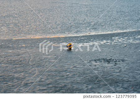Volleyball ball on the river ice. The ball on the ice. A ball on the water Volleyball ball on the river ice. The ball on the ice. A ball on the water 123779395