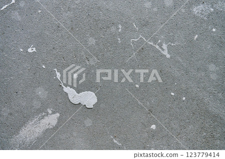 Close-up of concrete wall with white paint splashes and rough texture. Background for construction and renovation concep 123779414