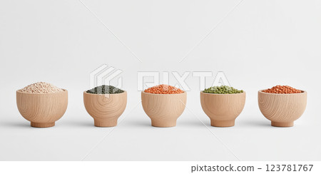Wooden bowls filled with various grains and legumes arranged in row on white background 123781767