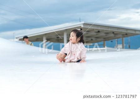 [Infants sitting on giant playground equipment] 123781797