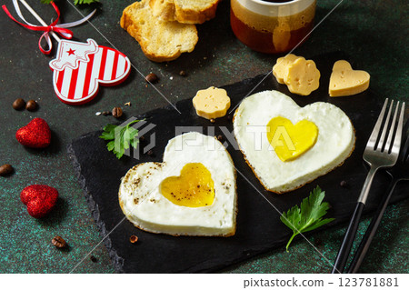 Breakfast on Valentines Day or brunch. Heart shape fried egg on slate plate. 123781881