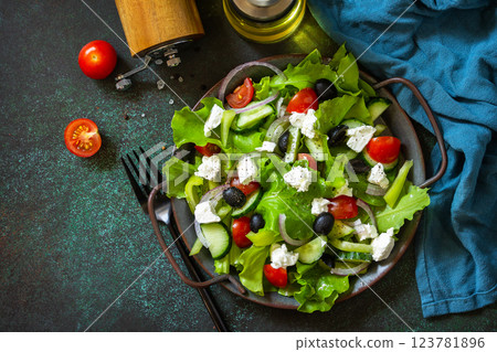 Healthy diet food. Greek salad of feta cheese, fresh cucumber, tomato, sweet pepper, lettuce, red onion and olives with olive oil. Top view flat lay. Copy space. 123781896