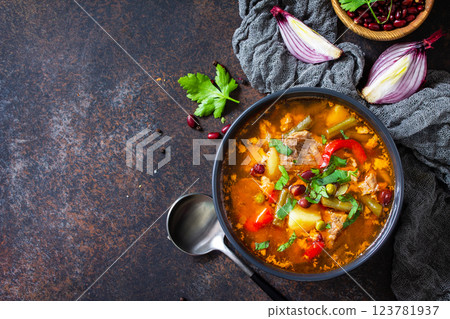 Homemade Meat Tomato soup with beef and bean stew, vegetables on a stone tabletop. Top view flat lay. Copy space. 123781937