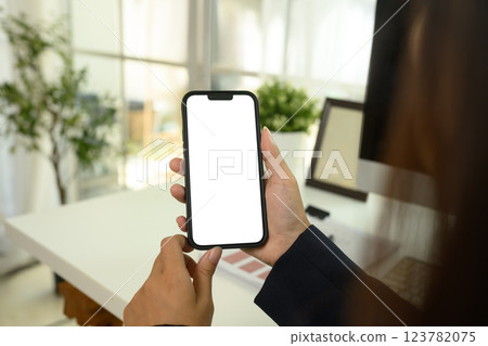 Close up of businesswoman holding a smartphone with a white screen Close up of businesswoman holding a smartphone with a white screen 123782075