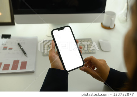 Close up of businesswoman using smartphone at office desk Close up of businesswoman using smartphone at office desk 123782077