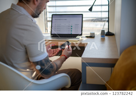 Diabetic man checking his blood sugar at home. Diabetic man checking his blood sugar at home. 123782242