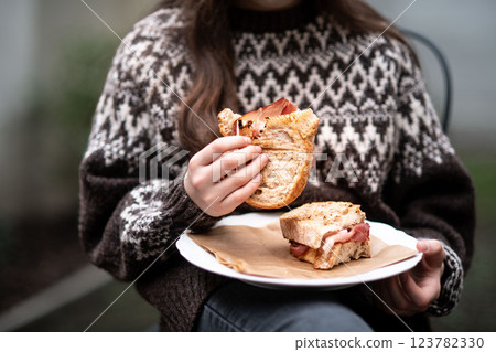 Girl enjoying a homemade baked sandwich with bacon. 123782330