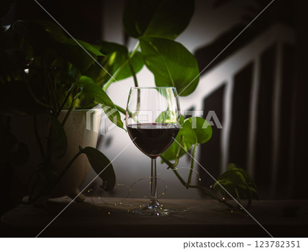 Glass of rich red wine with warm, elegant ambiance. 123782351