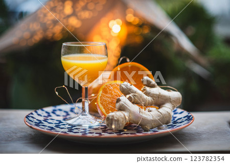 Ginger shot with fresh oranges and ginger root on rustic table 123782354