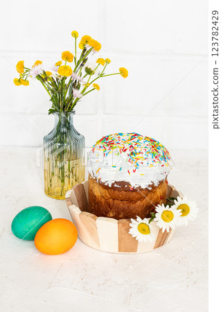 Easter cake, colorful eggs and yellow Ranunculus asiaticus. Easter cake, colorful eggs and yellow Ranunculus asiaticus. 123782429