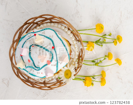 Easter cake in the wicker basket and yellow flowers. Easter cake in the wicker basket and yellow flowers. 123782438