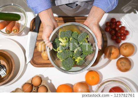 Middle-aged woman's hand holding fresh broccoli 123782761
