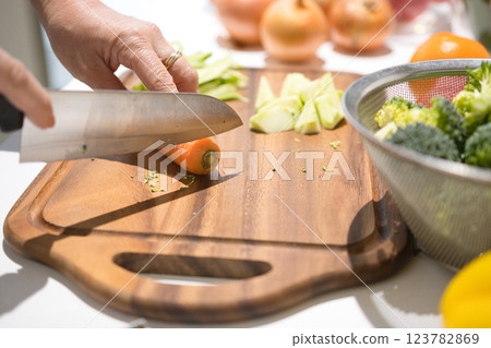 Hands of a middle-aged woman cutting vegetables 123782869