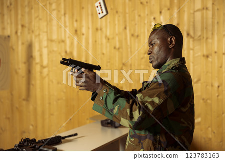 Man in uniform doing intensive shooting course designed to elevate individual skills beyond basic marksmanship. Military unit using pistol to engage targets at various ranges 123783163