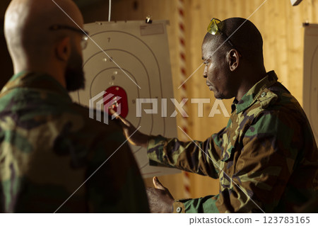Military units at shooting range training necessary combat skills, hitting targets. Army special operations forces enhancing combat readiness by shooting bullseyes, testing precision 123783165