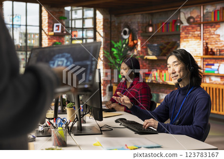 Call center multiethnic team using artificial intelligence chatbot to provide multilingual support. Multiracial customer support colleagues leveraging AI tools to translate clients interactions 123783167