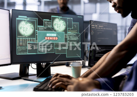 Computer scientist in server farm fighting hacker managing to pass firewall and stealing data. Employee receiving access denied notification on PC display in data center facility Computer scientist in server farm fighting hacker managing to pass firewall and stealing data. Employee receiving access denied notification on PC display in data center facility 123783203