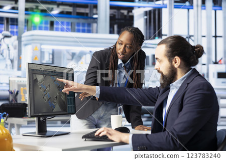 Photovoltaics factory manager showing woman how to do performance testing of solar panel designs. Team leader teaching intern how to improve solar panel configurations for cost reduction Photovoltaics factory manager showing woman how to do performance testing of solar panel designs. Team leader teaching intern how to improve solar panel configurations for cost reduction 123783240