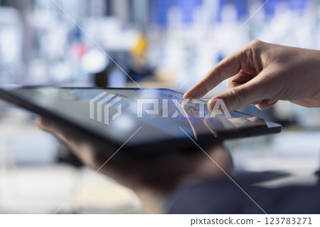 Photovoltaics factory worker uses tablet to review performance of robot arms placing solar panels on assembly lines. Specialist using device to inspect solar plant machinery, close up Photovoltaics factory worker uses tablet to review performance of robot arms placing solar panels on assembly lines. Specialist using device to inspect solar plant machinery, close up 123783271