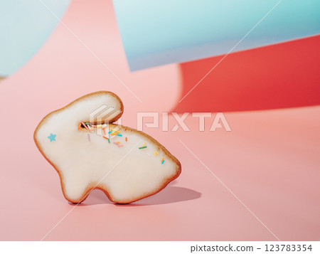 Easter bunny cookie on pink and blue curved paper pastel background with shadows. Happy Easter Day concept. Minimal Easter concept. Copy space. Easter cooking baking background. Easter bunny cookie on pink and blue curved paper pastel background with shadows. Happy Easter Day concept. Minimal Easter concept. Copy space. Easter cooking baking background. 123783354