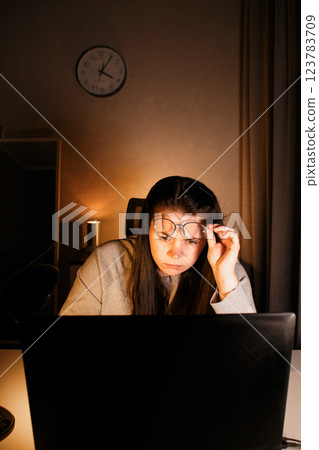 Hard working woman works on computer in her home office and tries to solve work problems. Feeling despair and burnt out from job issues. Hard working woman works on computer in her home office and tries to solve work problems. Feeling despair and burnt out from job issues. 123783709