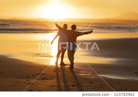 Couple walking on beach at sunset, enjoying freedom and togetherness 123783962