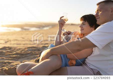 Couple enjoying wine on beach at sunset: romantic getaway Couple enjoying wine on beach at sunset: romantic getaway 123784093