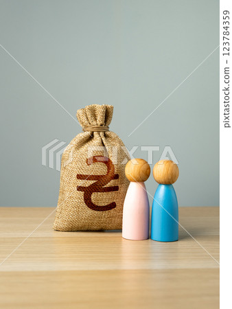 Money bag Ukrainian hryvnia and a couple of people. The concept of financial and social assistance for Ukrainian young families. 123784359