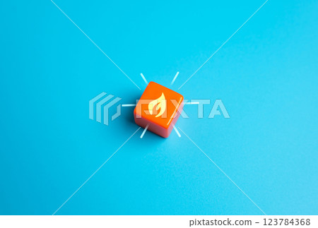 Burning flame on orange cube. Concept of hot offer, urgent message or profitable promotion. Exclusive discounts, marketing urgency, and flash sales. 123784368