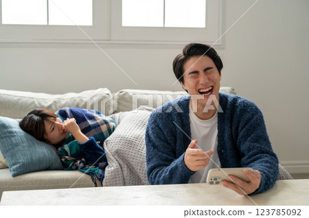 一名男子沉迷於智慧型手機而無暇照顧生病的妻子 一名男子沉迷於智慧型手機而無暇照顧生病的妻子 123785092