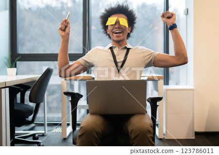 Man with yellow notes on face having fun in office 123786011