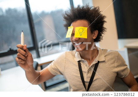 Businessman with yellow sticker on his face in modern office 123786012