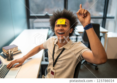 Man with yellow notes on face having fun in office 123786014