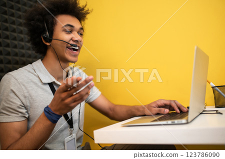 Young man sitting at the laptop and talking to the client online 123786090