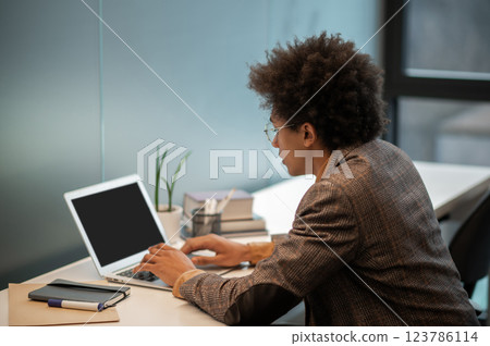 Businessman sitting at the laptop with a serious look and thinking Businessman sitting at the laptop with a serious look and thinking 123786114