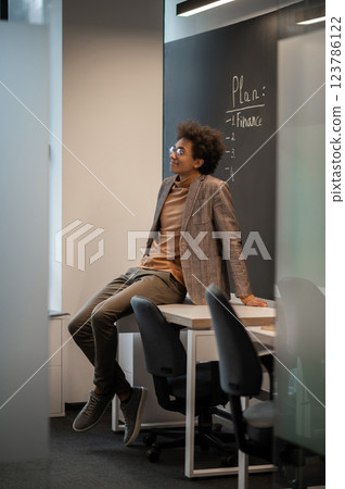 Young businessman looking confident and contented in the office Young businessman looking confident and contented in the office 123786122