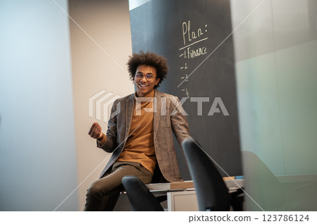 Young businessman looking confident and contented in the office Young businessman looking confident and contented in the office 123786124